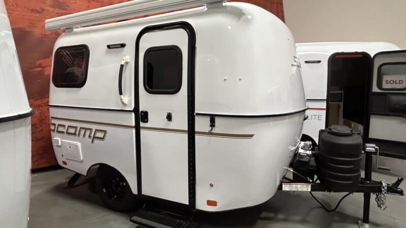 White Scamp 13 with an awning parked in a showroom