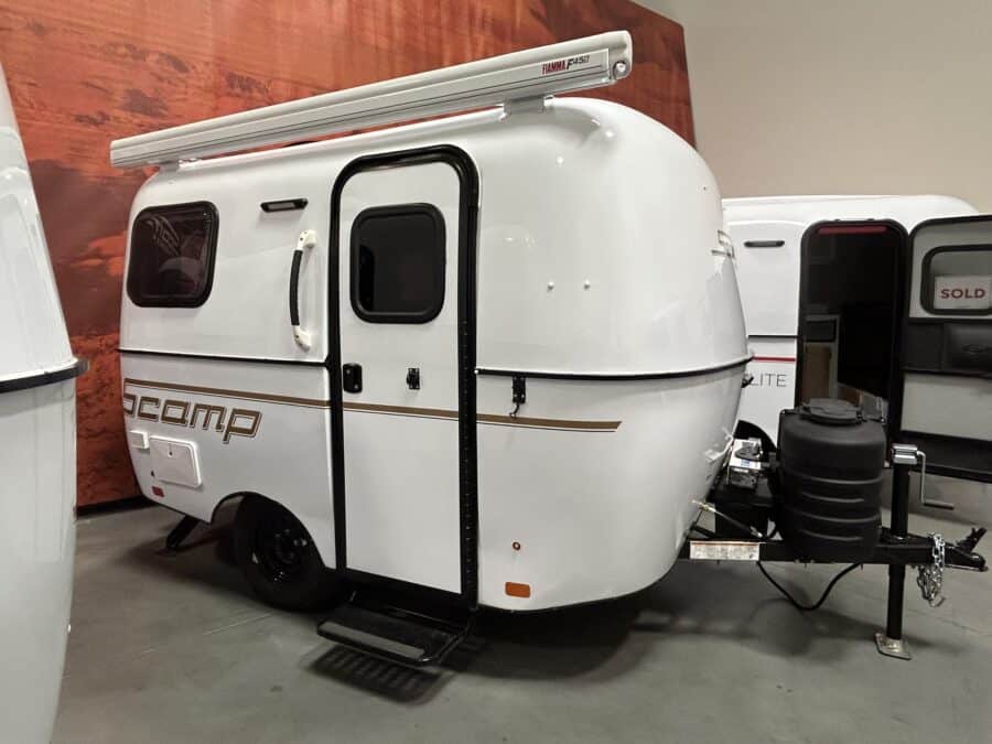 White Scamp 13 with an awning parked in a showroom