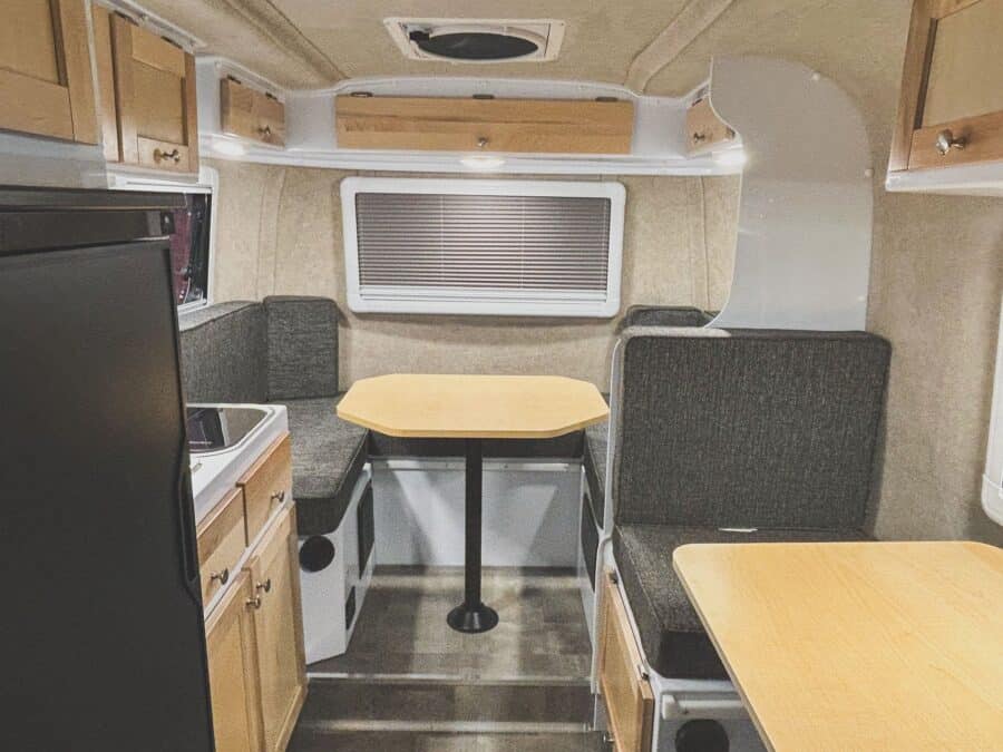 View toward the rear dinette past the refrigerator and side table