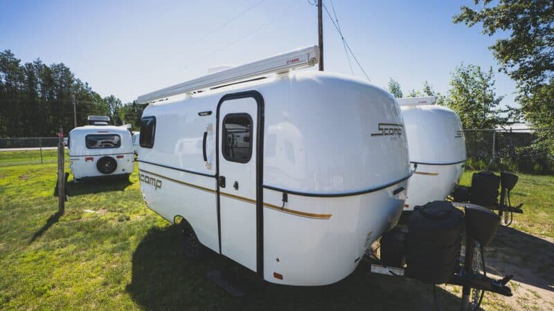 White Scamp 16 with an awning on a grassy lot