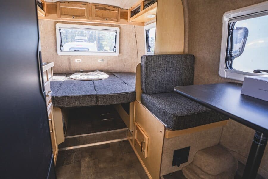 Rear bed and side dinette with dark grey cushions
