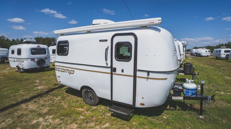 White Scamp 16 with an awning in a field of trailers