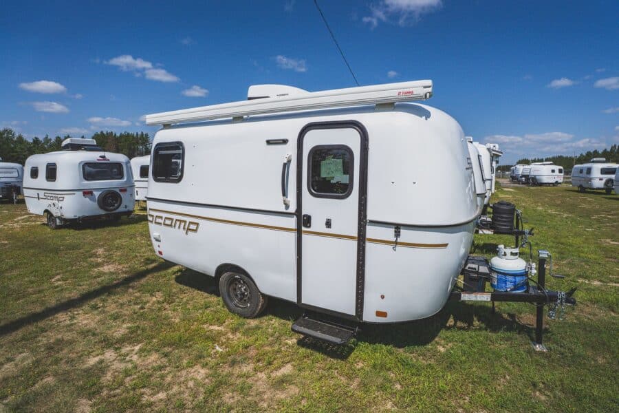 White Scamp 16 with an awning in a field of trailers