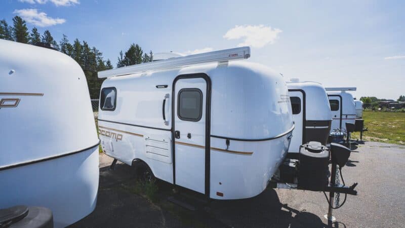 White Scamp 16 on a lot next to other trailers