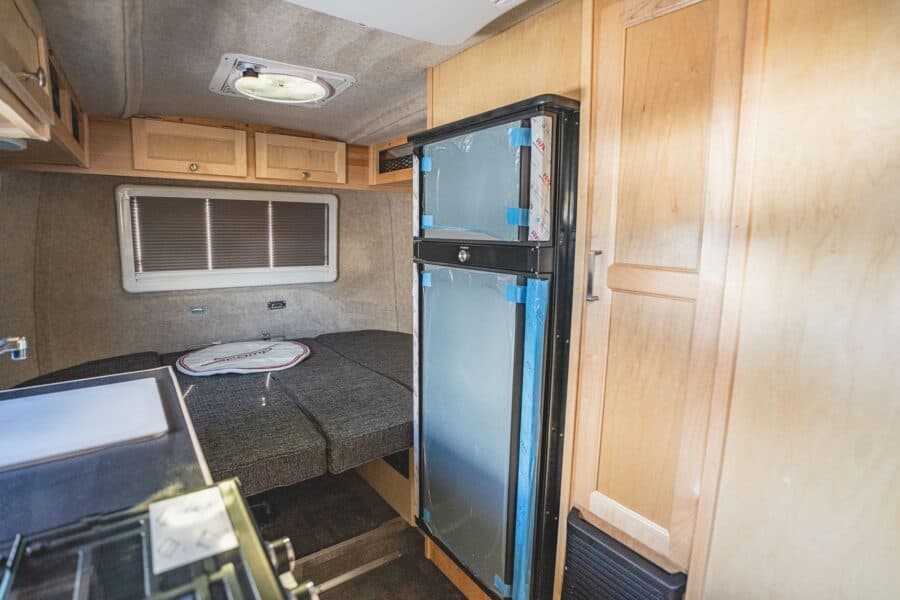 Large refrigerator next to the galley, rear bed beyond