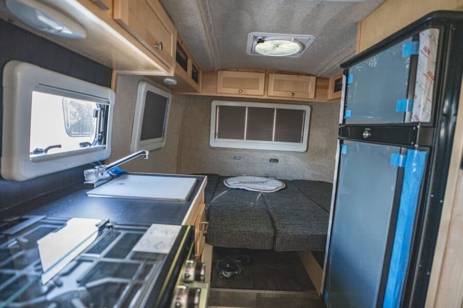 Stovetop and sink with the rear bed in the background