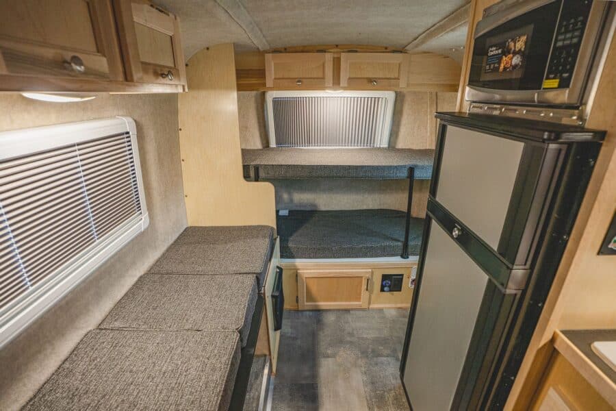 Front sofa bunk beside a tall refrigerator