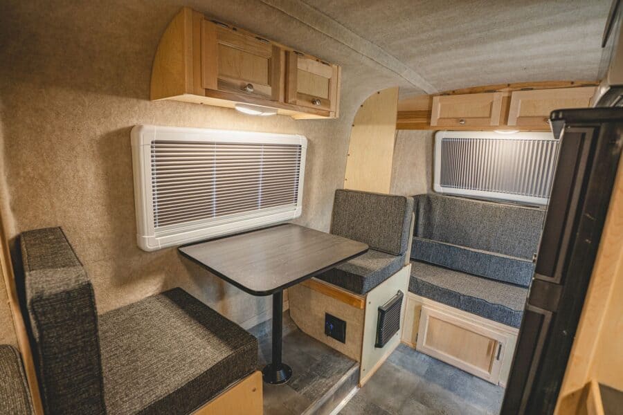 Side dinette table between two cushioned benches