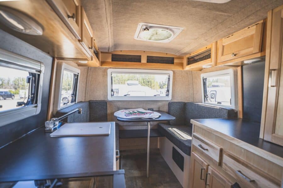 Rear dinette with a table, maple cabinets, and three windows