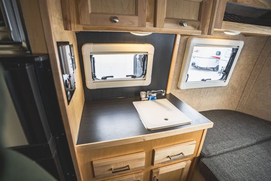 Galley sink with a dark counter and maple cabinets