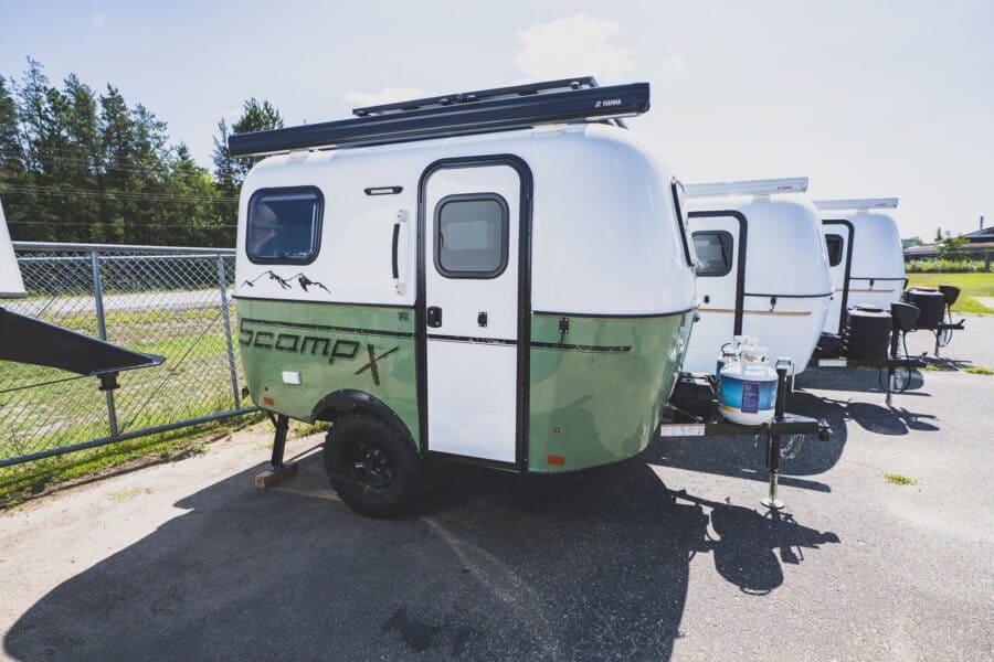 Scamp X with an olive green lower shell and roof rack in a parking lot