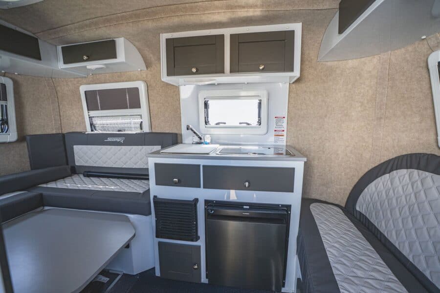Galley and U-shaped rear dinette with grey quilted cushions