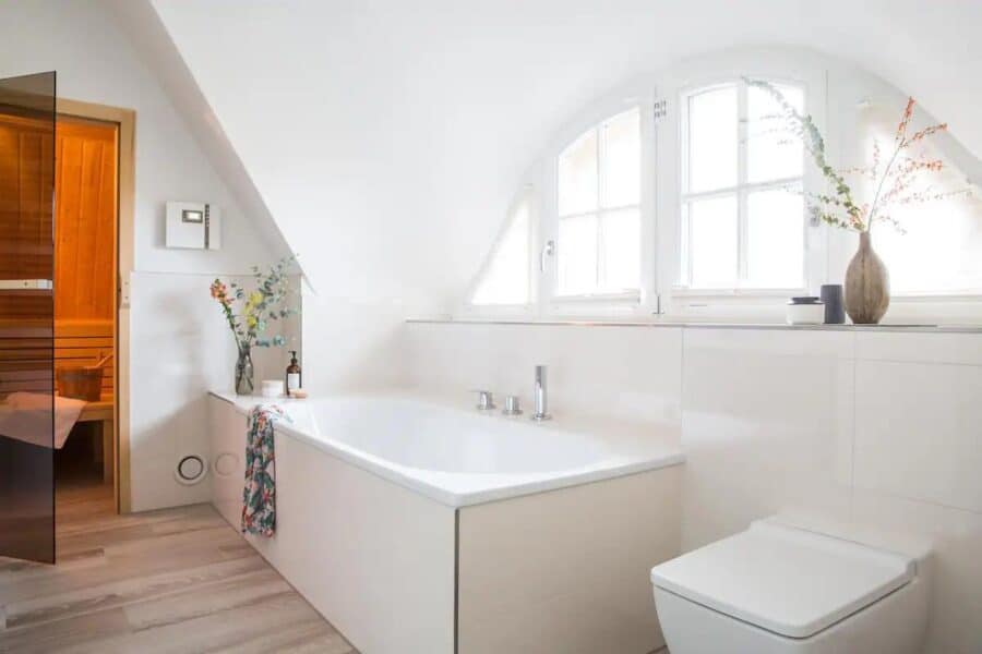Bright bathroom with a modern bathtub and large windows in a tiny house.