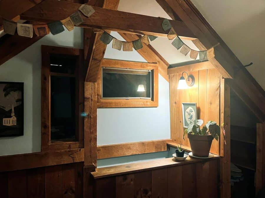 Warm wooden interior of a romantic Vermont cabin with cozy decor and soft lighting.