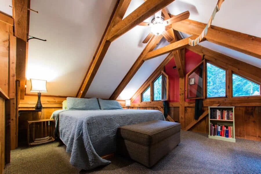 Warm and inviting rustic cabin bedroom with wooden beams and cozy decor in Vermont.