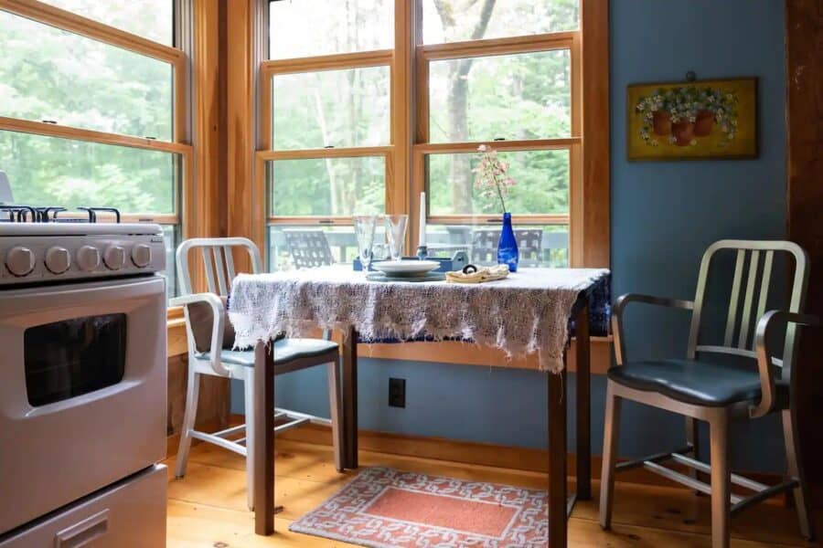 Small cozy cabin dining area with large windows and rustic decor.
