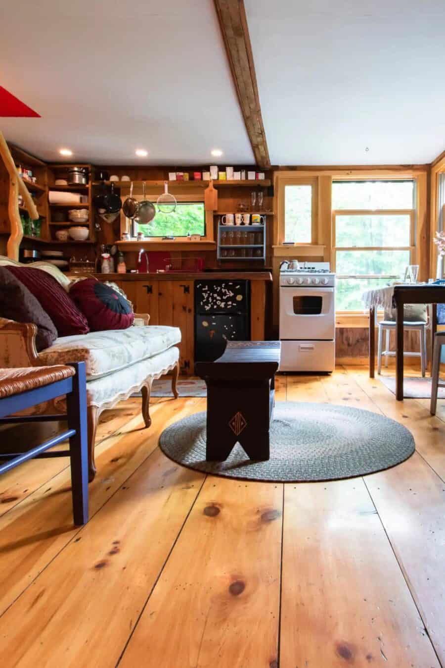 Cozy tiny cabin kitchen with wooden accents, stove, and natural light, perfect for a romantic getawa.