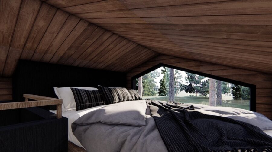 Interior view of a cozy tiny cabin bedroom with wooden walls and a large window overlooking nature.