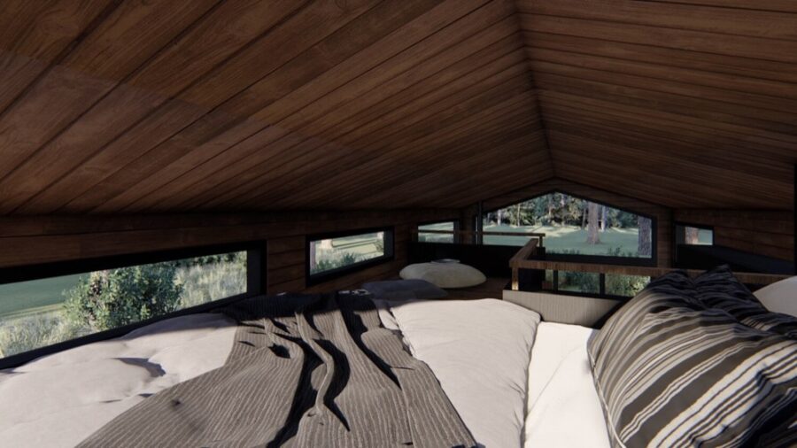Interior view of a small, cozy cabin with wooden walls and large windows overlooking nature.