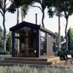 Compact ShadowPine Cabin with modern design in a lush forest environment.
