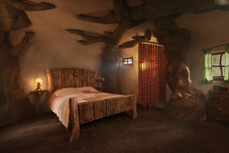 Cozy bedroom inside Shrek's swamp-inspired tiny house in the Scottish Highlands. Unique rustic desig.