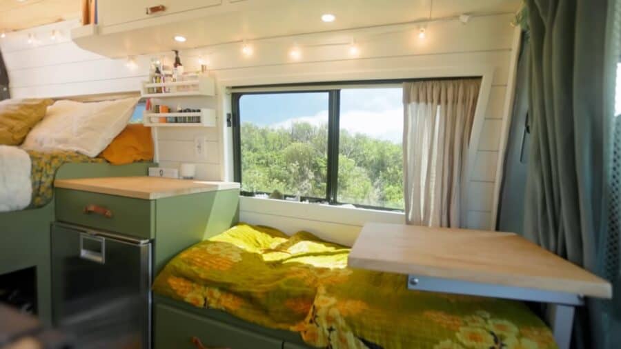 Compact tiny house bedroom with large window and natural light.