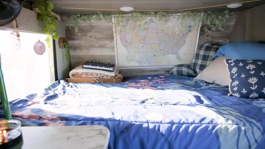 Compact tiny house bedroom with a map of the United States on the wall.