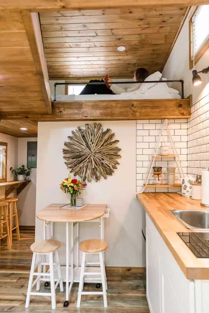View of the Shiva tiny home living and kitchen area with the sleeping loft above