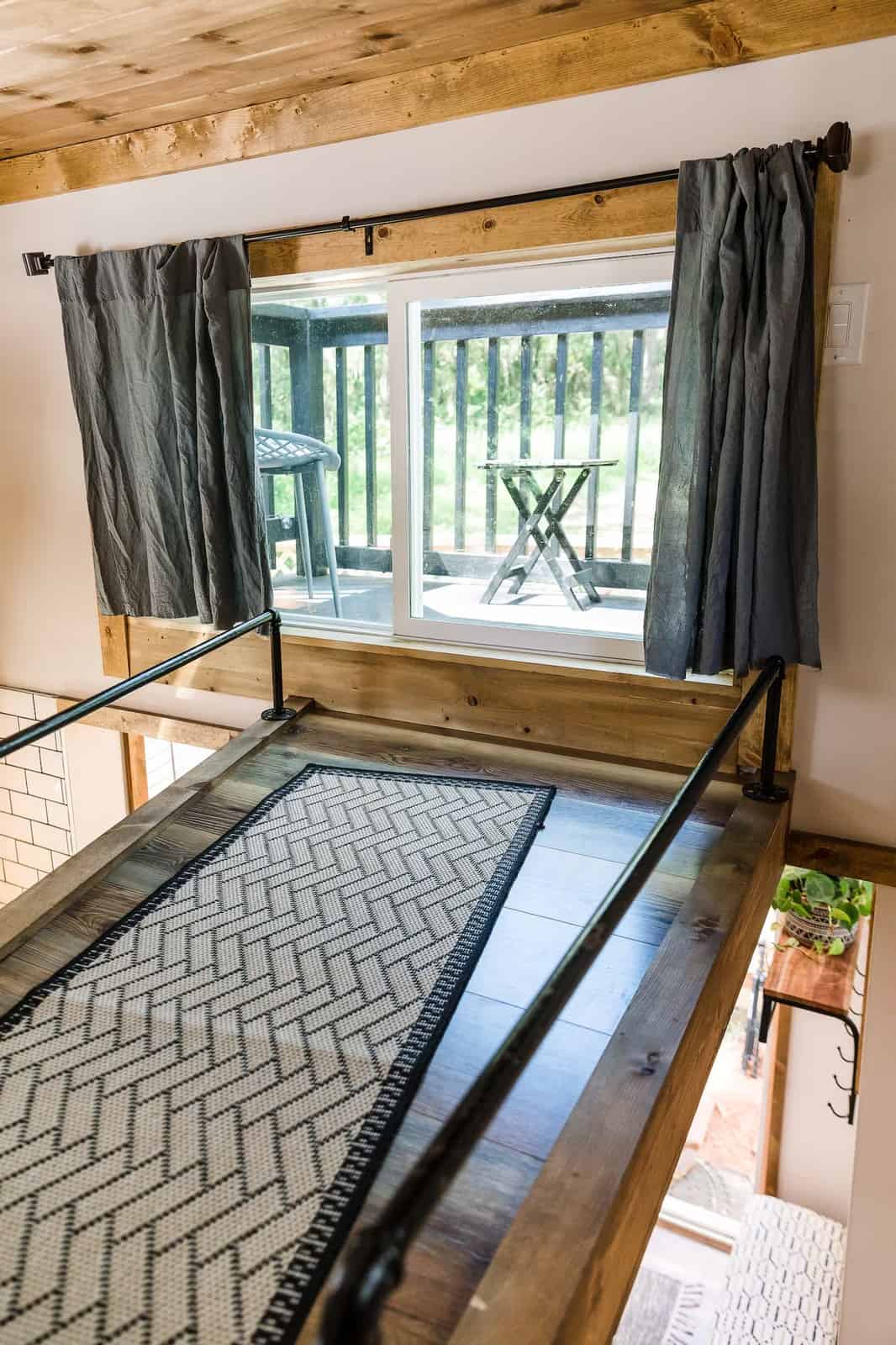 Loft window looking out to the walkover balcony and rooftop deck of the Shiva tiny home