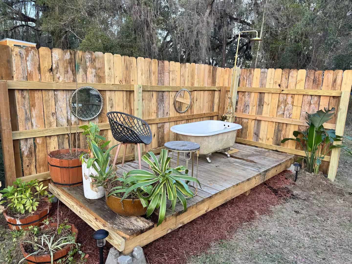 Outdoor clawfoot soaking tub on the plant-filled deck at the Shiva tiny home