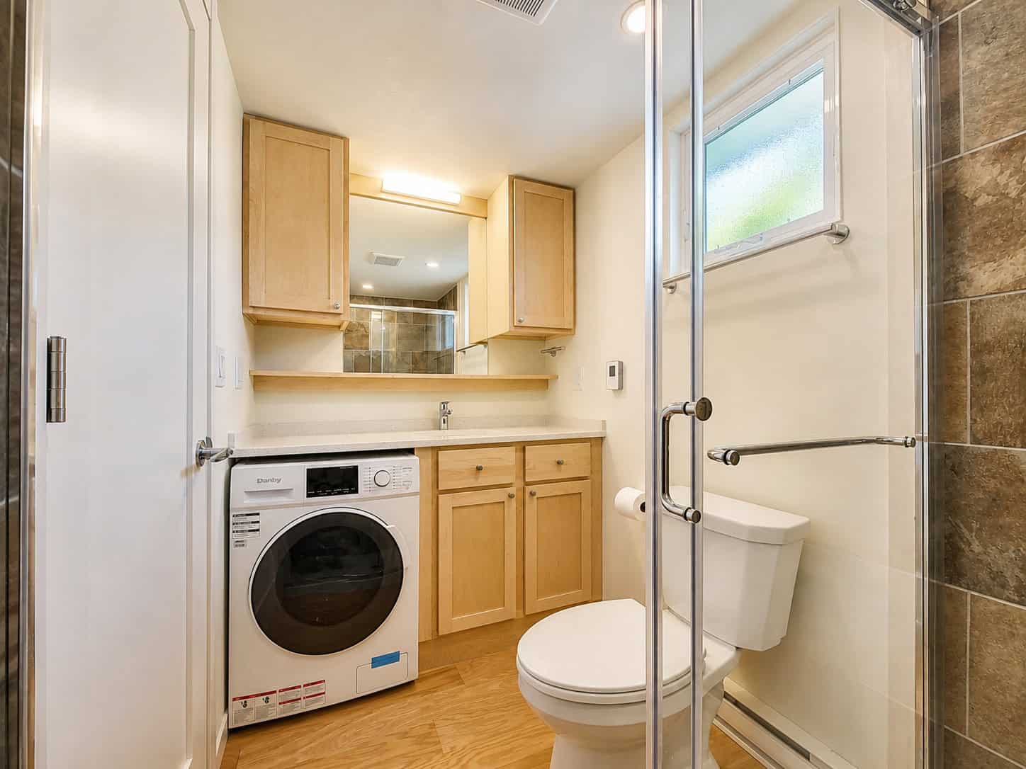 SHORELINE Glass House bathroom with washer dryer and vanity storage