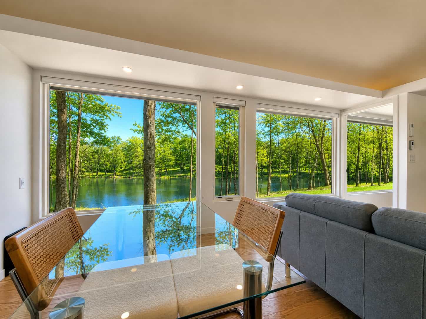 SHORELINE Glass House dining area with panoramic lake views through floor-to-ceiling windows