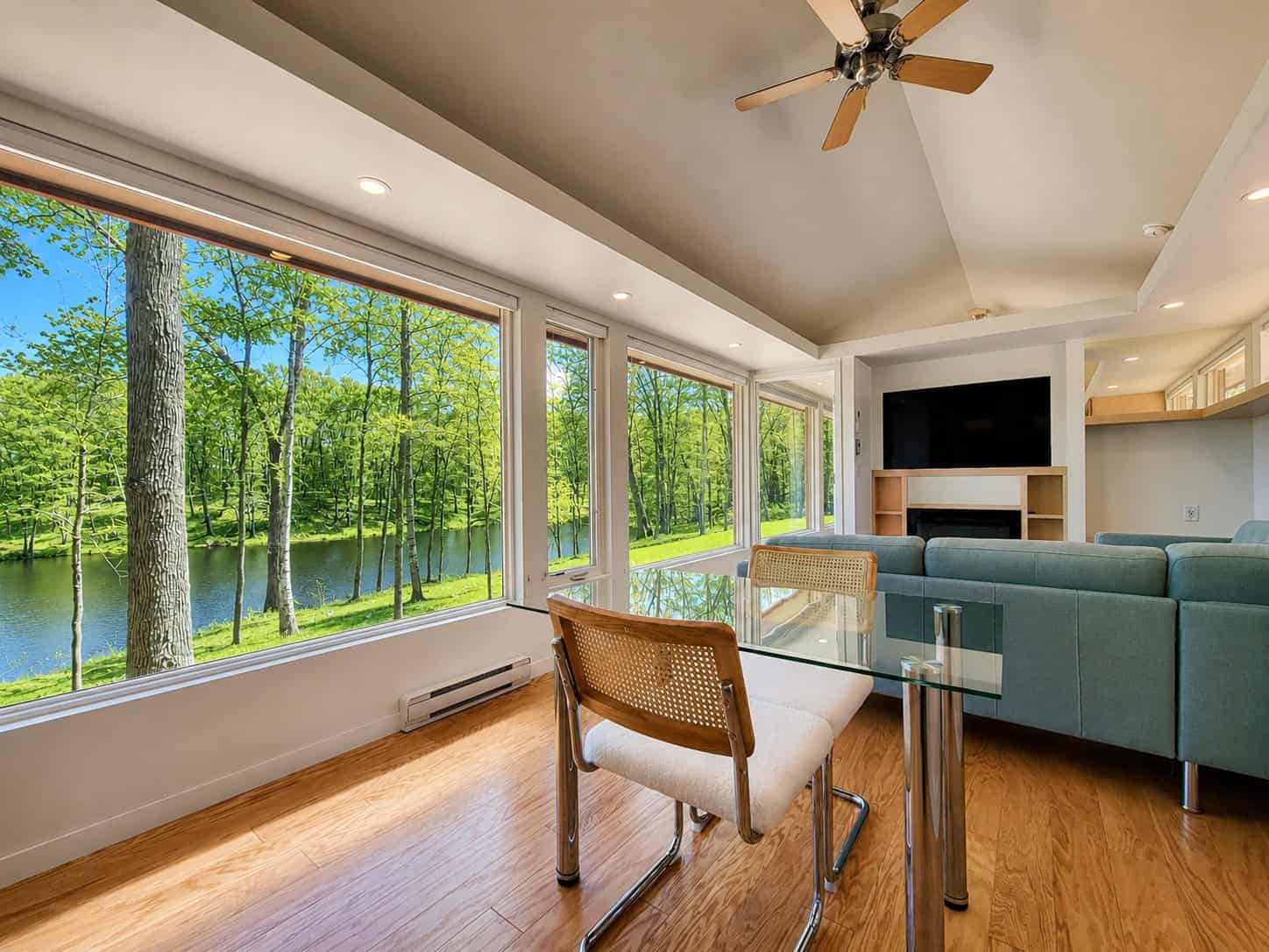 SHORELINE Glass House living room with sectional couch, fireplace, Smart TV, and panoramic lake views