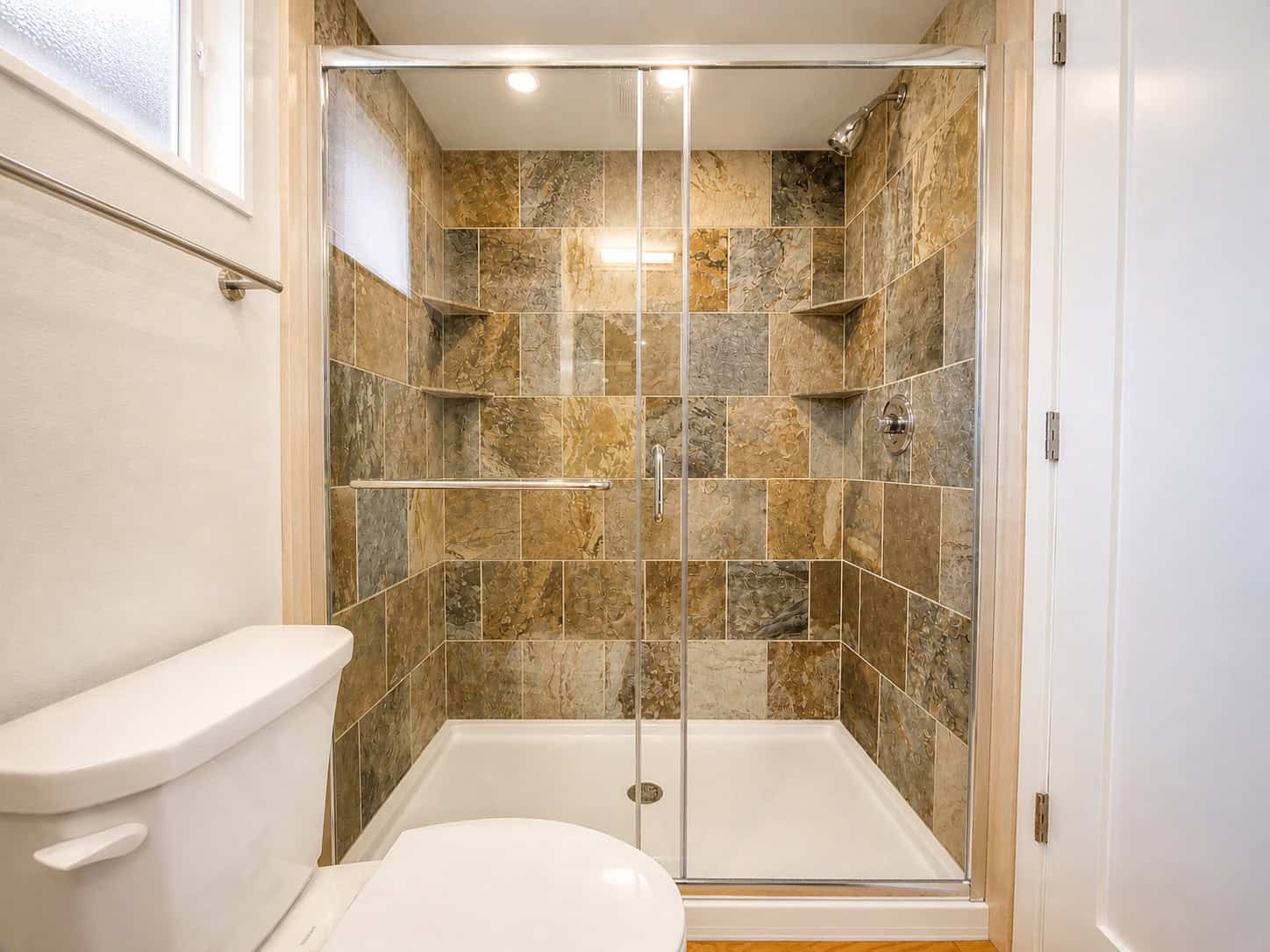 SHORELINE Glass House walk-in tile shower with natural stone and glass doors