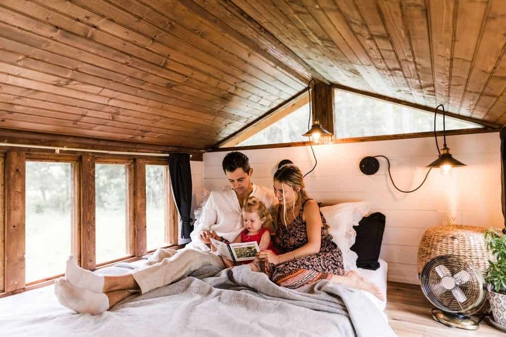 The Simplify Further family relaxing and reading together inside one of their tiny homes