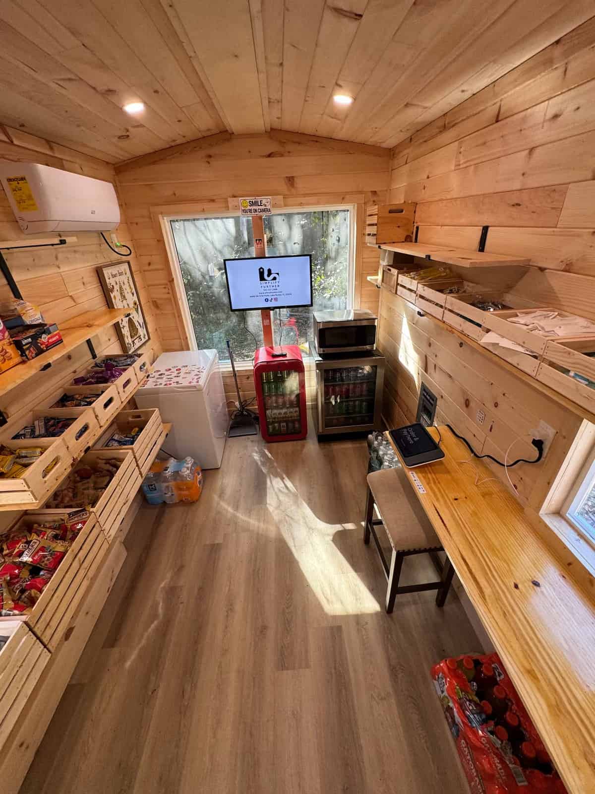 Inside the Simplify Further tiny convenience store, stocked with snacks, drinks, and essentials