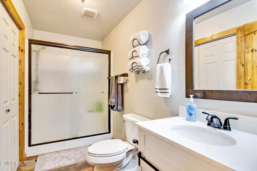 Small bathroom in a tiny house with shower, toilet, and modern sink.
