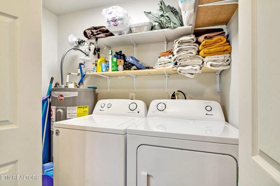 Compact laundry space with washer, dryer, and shelves in small Tennessee home.