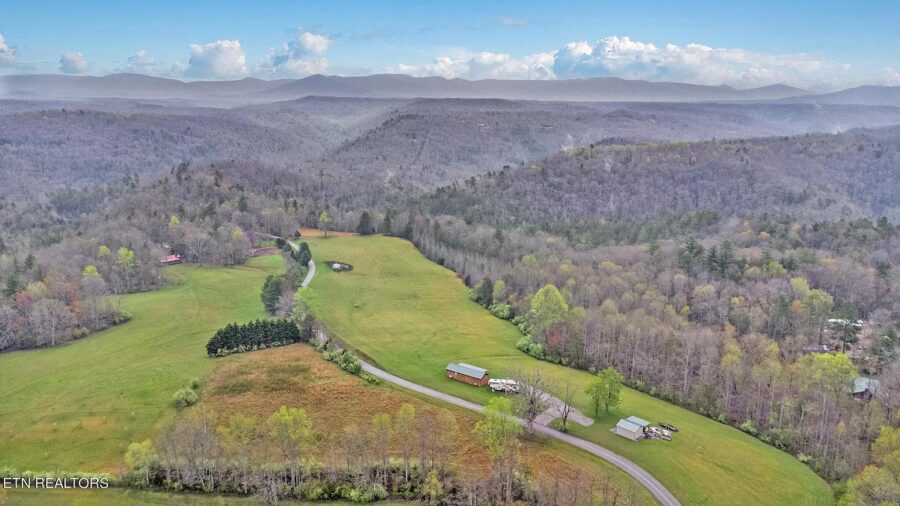 Beautiful small home on 12 acres in Tennessee with RV parking and hookups, surrounded by lush greene.