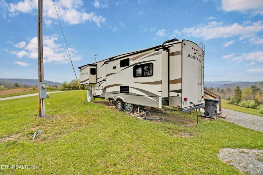Tiny house on wheels with RV hookups in a scenic Tennessee setting.