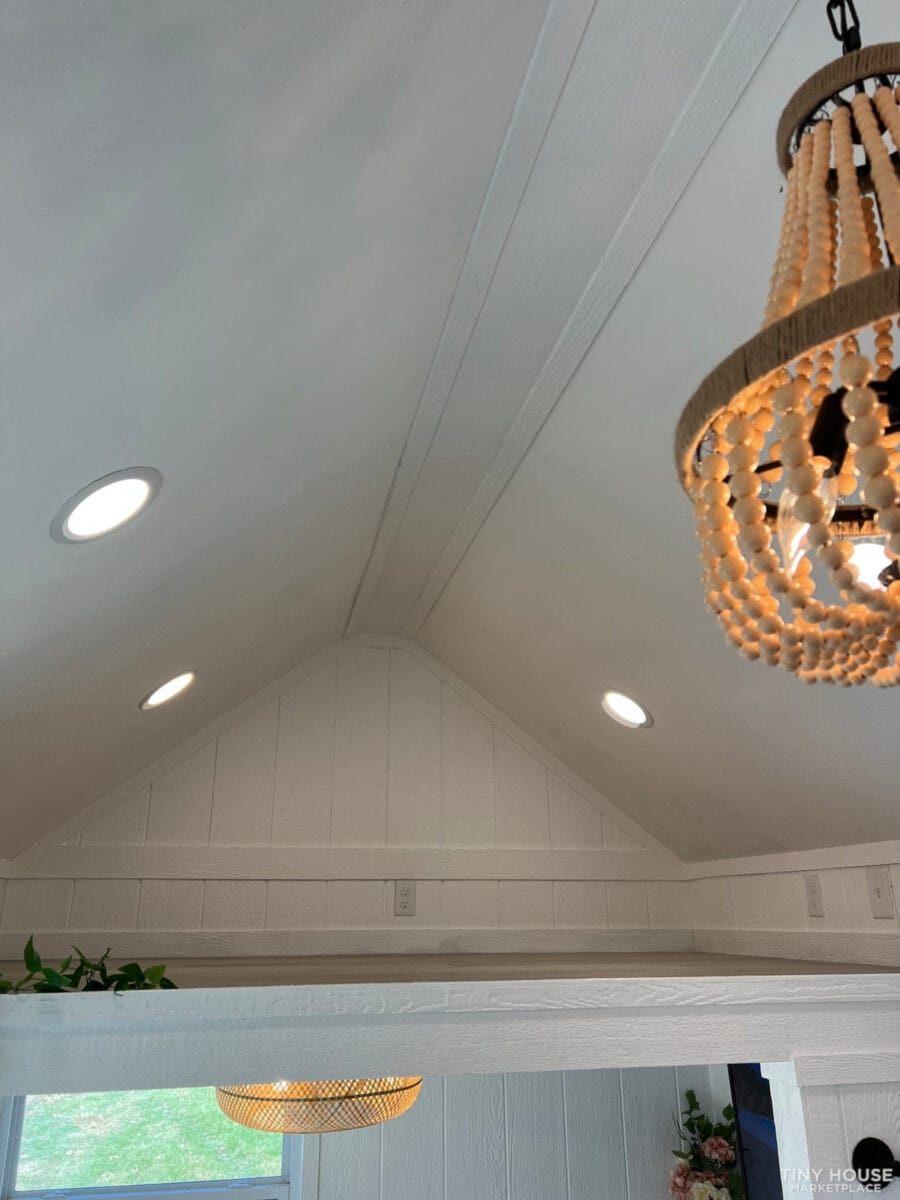 Bright interior ceiling with recessed lighting and a decorative beaded chandelier.