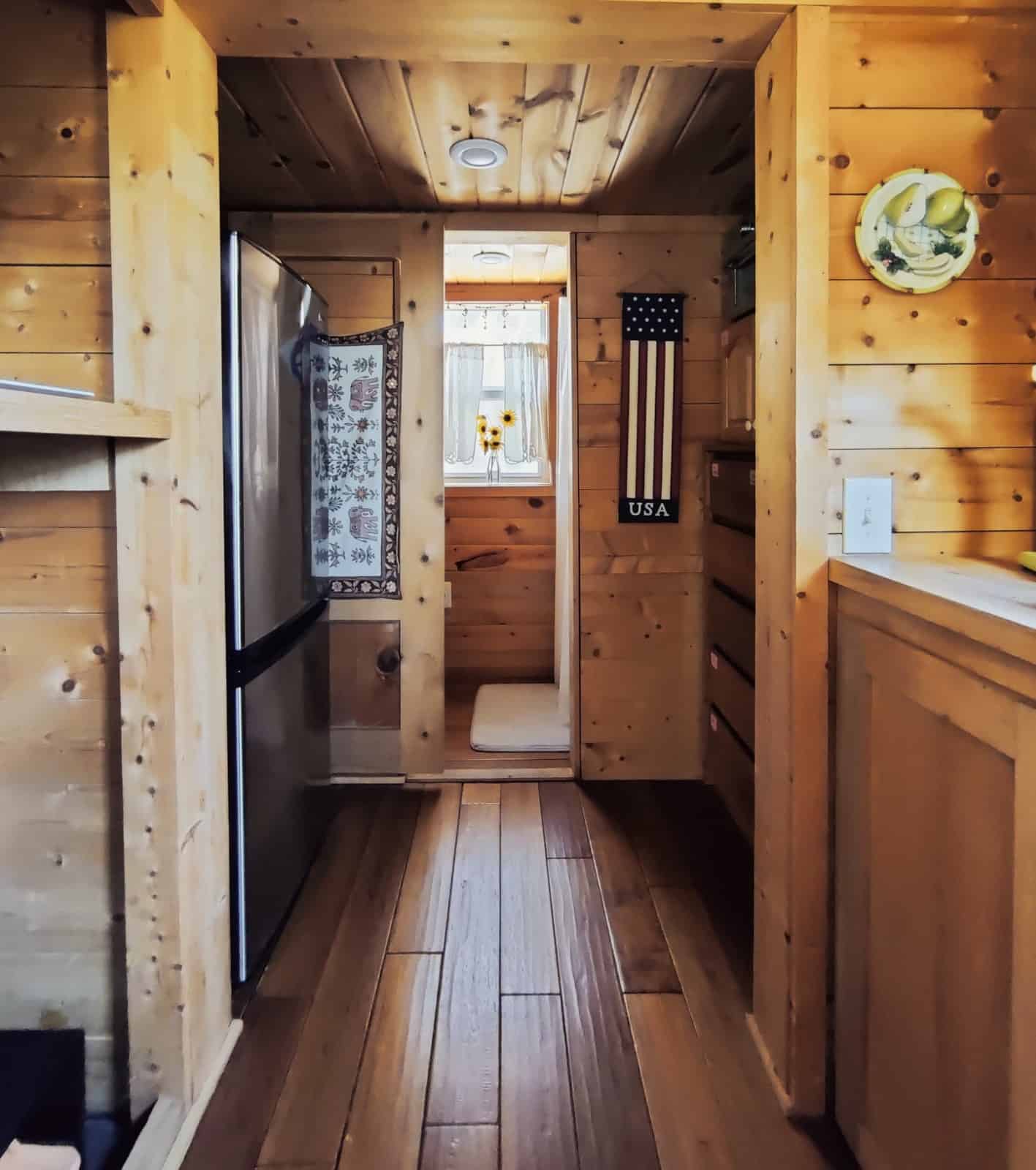 View through the interior toward the full-size refrigerator and bathroom
