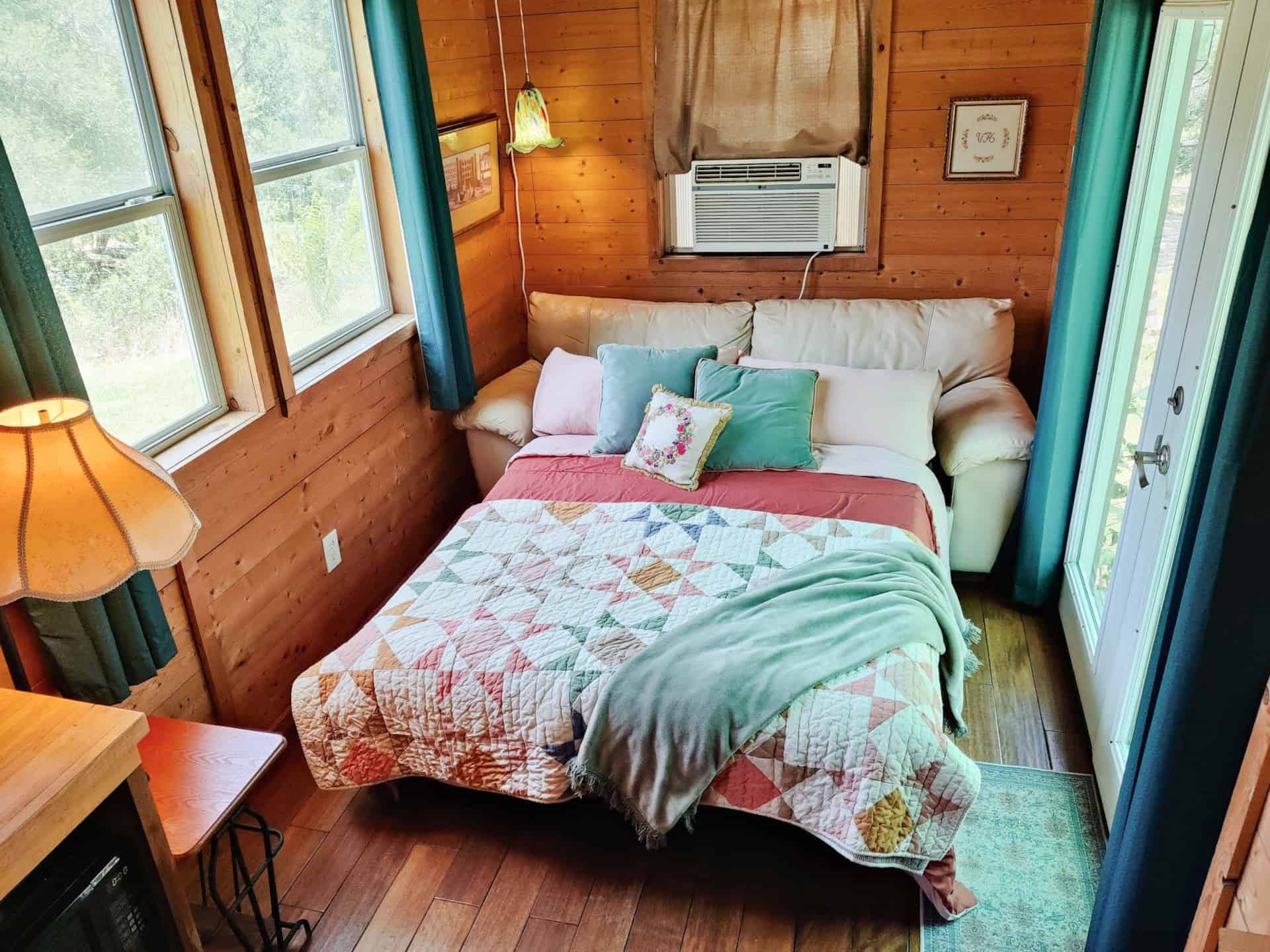The living room sofa made up as a bed with a patchwork quilt