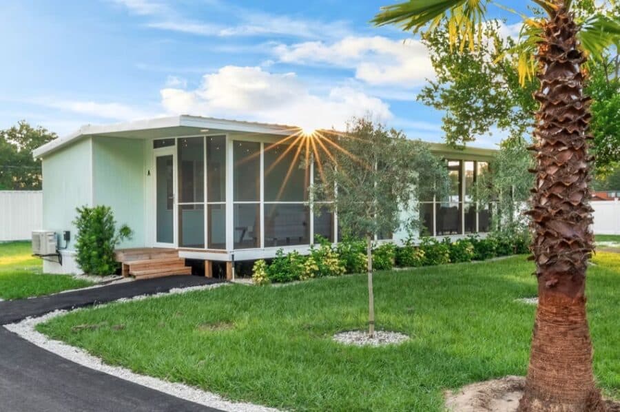 Charming tiny house with modern design, large screened porch, and lush landscaping in Tampa, Florida.