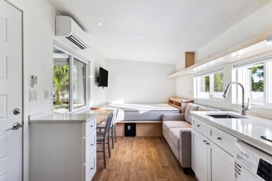 Cozy tiny house living space with modern kitchen and large windows in Tampa, Florida. Perfect for sm.
