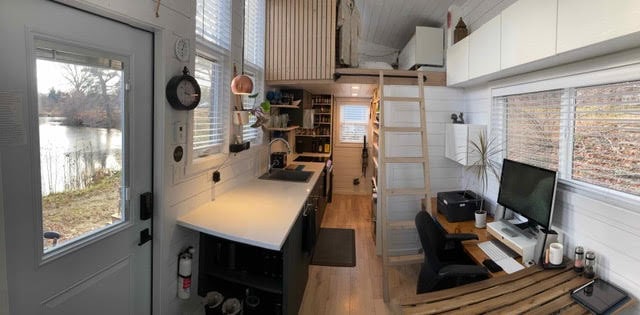 Cozy tiny house interior with compact kitchen, workspace, and loft for efficient living. Perfect for.