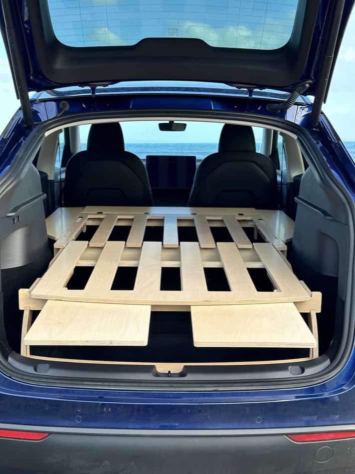 Camping platform for Tesla Model Y, S, or X with wooden slats and sleeping area. Perfect for small s.