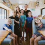 Cozy family bus interior with six children and parents, showcasing small space living and family adv.