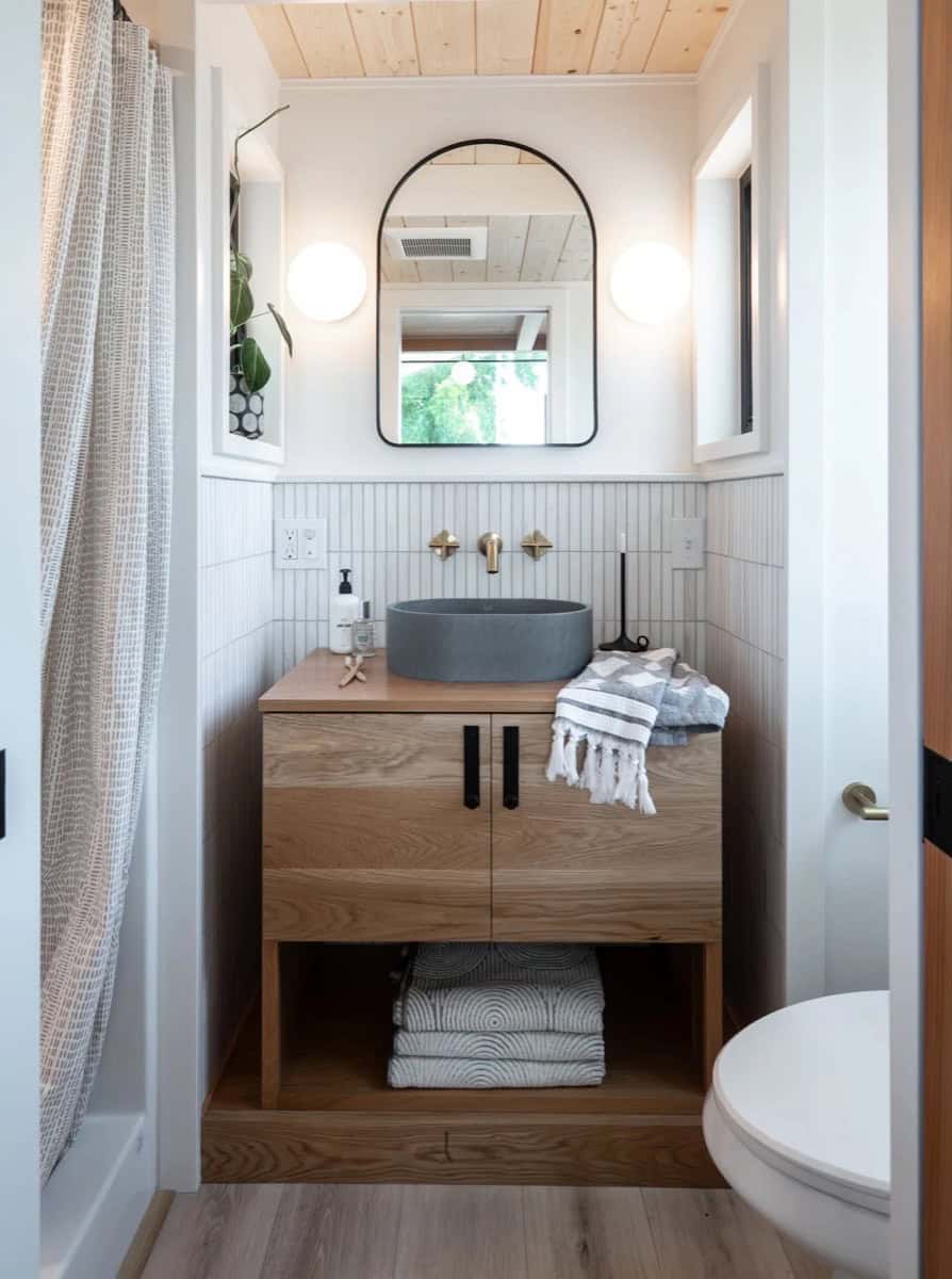 Terra Urban tiny house bathroom with concrete vessel sink, wood vanity, arched mirror and cedar ceiling
