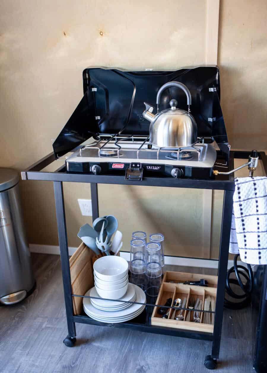 Compact tiny kitchen with a stove and kettle in a modern tiny house.